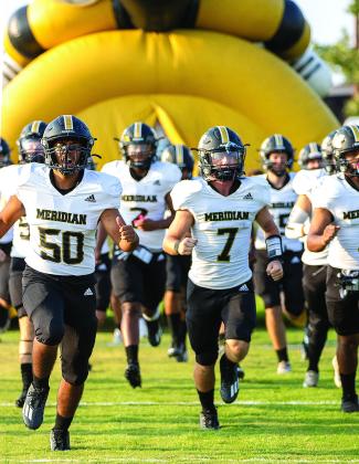 Meridian Yellowjackets take the field for the first time in the 2023 Texas high school football season on the road at Lindsay (above left); Junior Ian Gomez (3) makes a move around a Lindsay Knight defender last Friday night (above). Photos by Wendy Orozco courtesy of Brett Voss’ The Sports Buzz