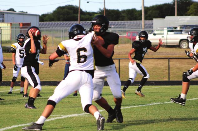 Yellowjacket offense looks to get rid of the ball in an attempt to gain some yardage against the Crawford Pirates at their first scrimmage of the season at Jacket Stadium Friday evening. Ashley Barner | Meridian Tribune