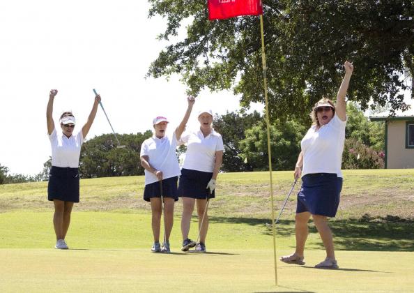 Christen Jackman finishes her drive with a long put for a birdy on a par 3 as her teammates Marian Merrill, Jessica Chapman, Chris Brandt cheer at the BARK Golf Tournament Saturday at the Bosque Valley Golf Club. Allen D. Fisher | The Clifton Record