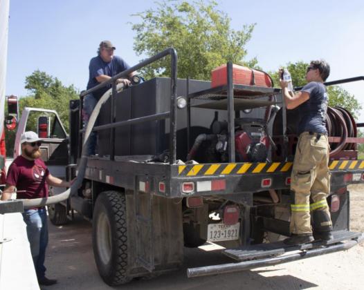 Clifton and Valley Mills Fire Departments refill their tanks with water at a grass fire started by a tractor Friday on County Road 3355, north of Valley Mills. Allen D. Fisher | Meridian Tribune
