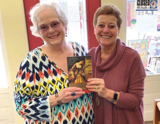Susan Ferguson delivers a book to Meridian Publlic Library Director Mary Anne Woerner in Meridian. Courtesy Photo
