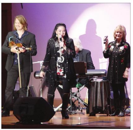 Award-winning country singer Crystal Gayle (center) graces the stage with her sister Peggy Sue and band mates during her performance at the Bosque Arts Center Friday eventing. B Debra Evans | Bosque Arts Center B