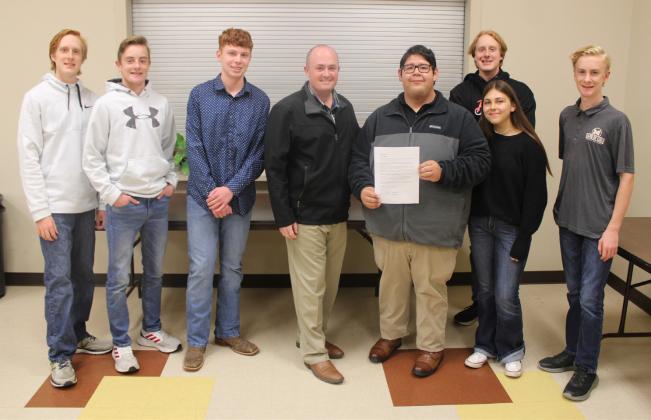 The City of Meridian approved designating November 7 as 'Band of Gold' Day in honor of the Meridian High School Marching Band's first-ever appearance at the UIL 1A State Marching Band Competition this year. Representing the band (back, from left) were Colby Cummings, Hayden Cummings, Noah Smith, Caleb Cummings, Maryn Roberson, and Dawson Cummings. Meridian Mayor Ryan Nieuwenhuis (front, from left) presented the proclamation to MISD Band Director Daniel Yguerabide. Nathan Diebenow | Meridian Tribune