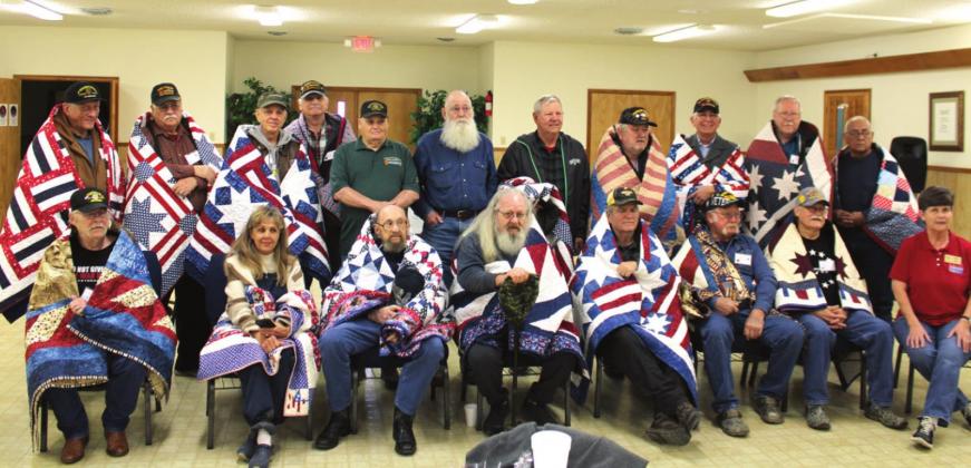 Debbie Stubbs presents a group of local veterans with Quilts of Valor at the Church of Chirst in Clifton in February. Stitched in shades of red, white and blue, quilts are awarded to veterans to thank them for their service and to offer a bit of warmth and comfort while letting them know they are not forgotten. Ashley Barner | Meridian Tribune