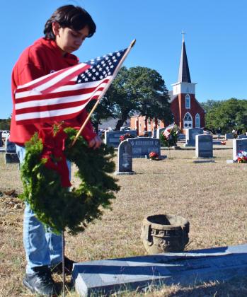 Abel Pederson laid a wreath at the headstone of veteran Johnny C. Olson at Norse Cemetery as a part of the local support to the National Wreaths Across American Day, Saturday, December 16. Olson served as a Private First Class during World War II. He was a lifelong member of Our Savior’s Lutheran Church. Photo Courtesy by Ral Aars